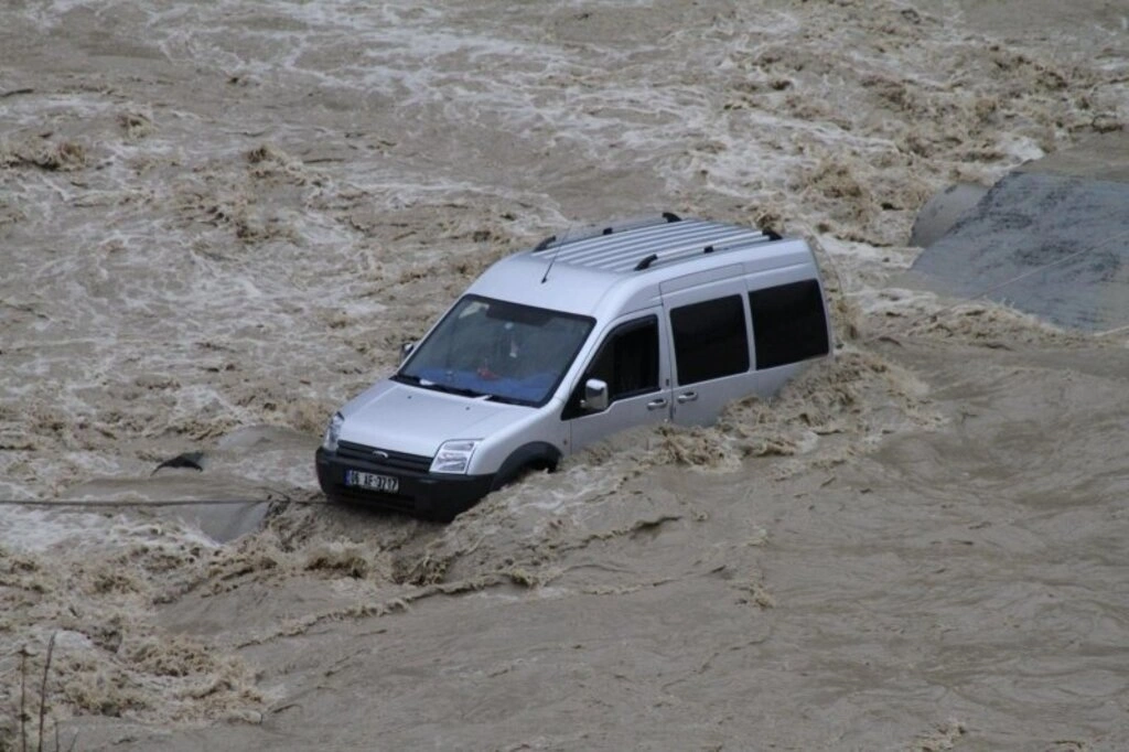Çarşamba ilçesinde Abdal Irmağı üzerindeki beton yoldan karşıya geçmeye çalışan kamyonet, menfezlerin çökmesi sonucu su içinde mahsur kaldı.
